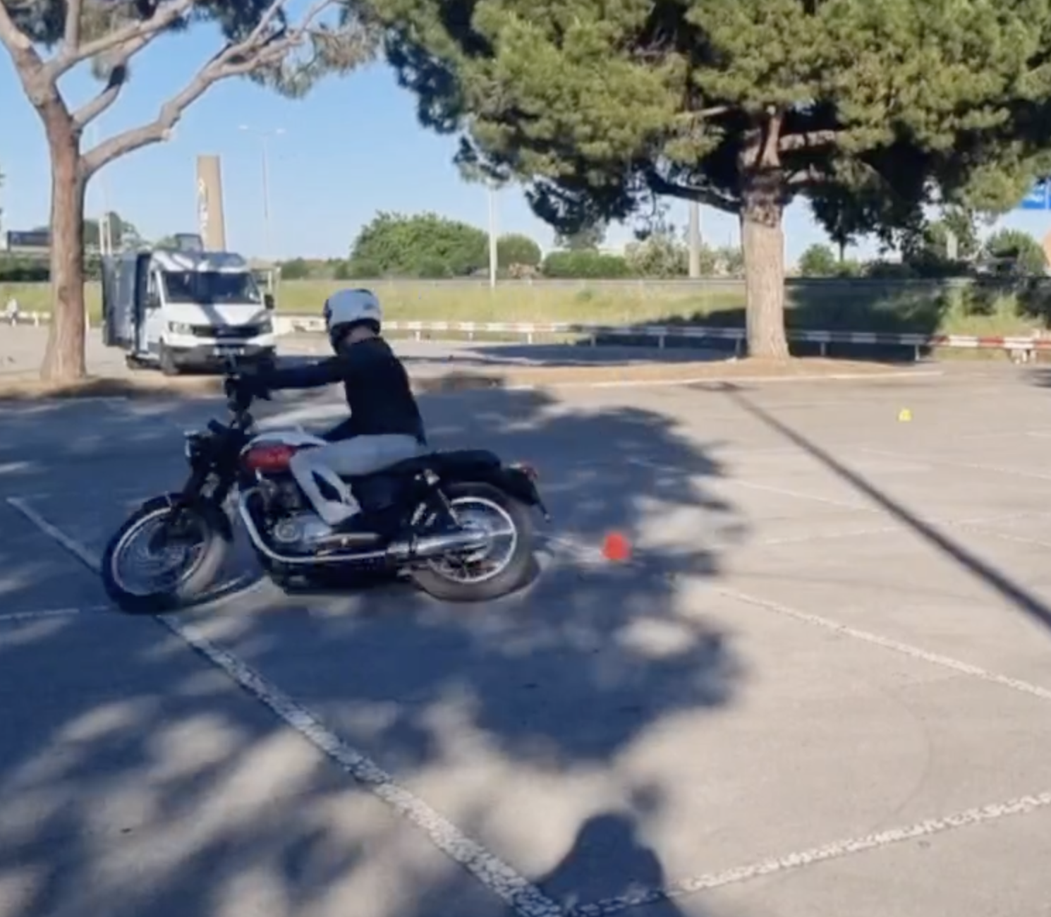 MotoBarna rider practicing MotoGymkhana around cones in a Barcelona parking lot