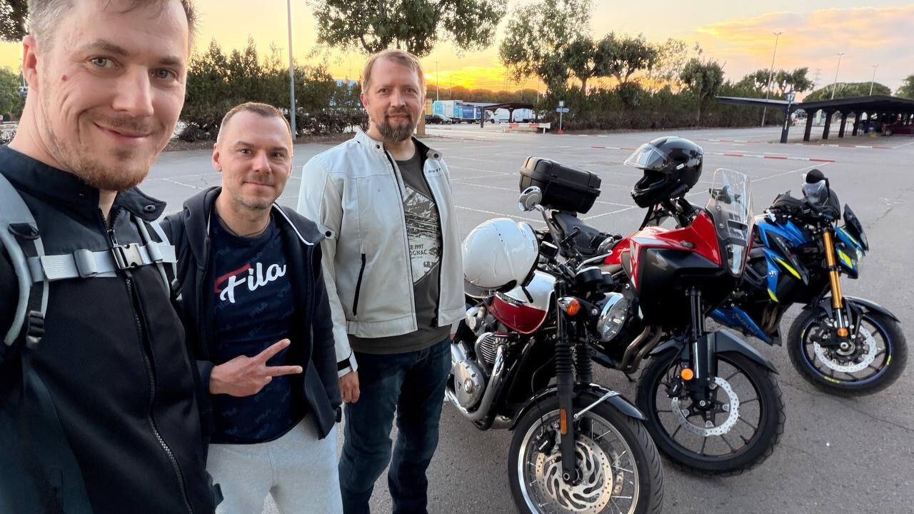 MotoBarna riders hanging out beside motorcycles after Sunday practice